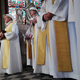 Priests in protective headgear celebrate Saturday’s mass.